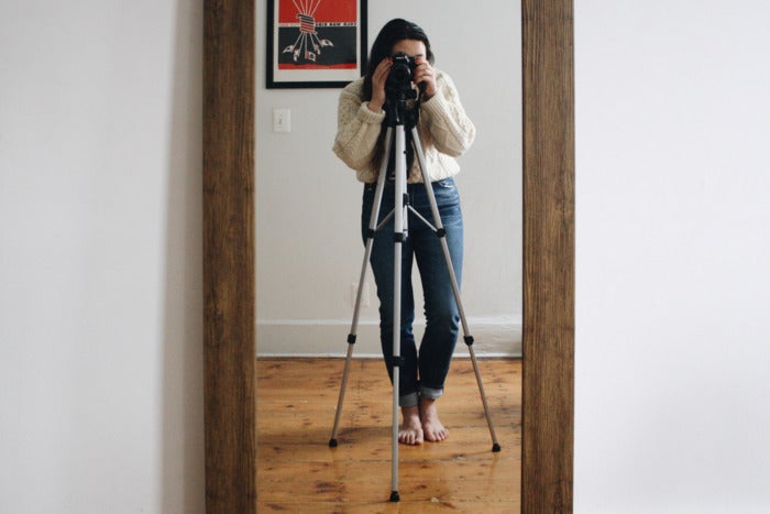 Woman taking a picture of herself using a tripod.